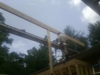 Carpenter setting a ridge beam over a new addition frame — Ice Dam Removal by Roofing Brothers in Toledo
